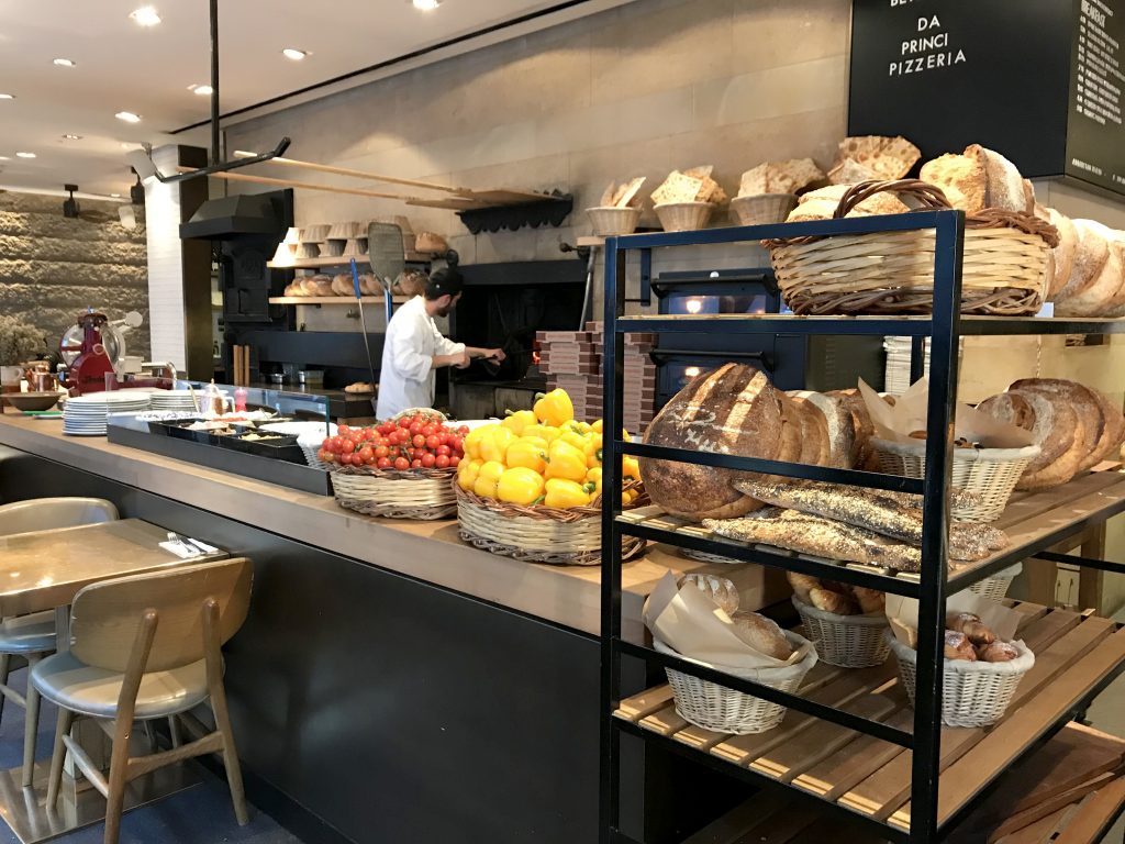 Baker with breads and electric oven