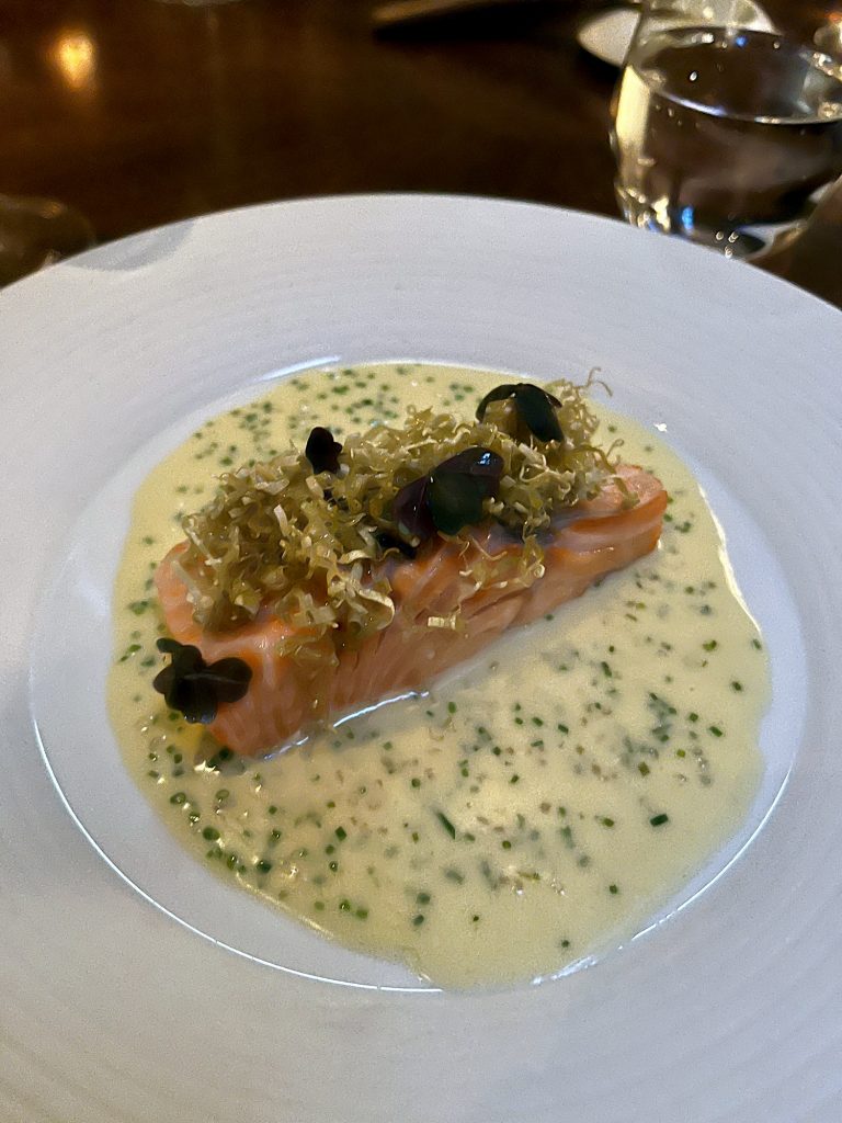 A slice of salmon with beurre blanc sauce