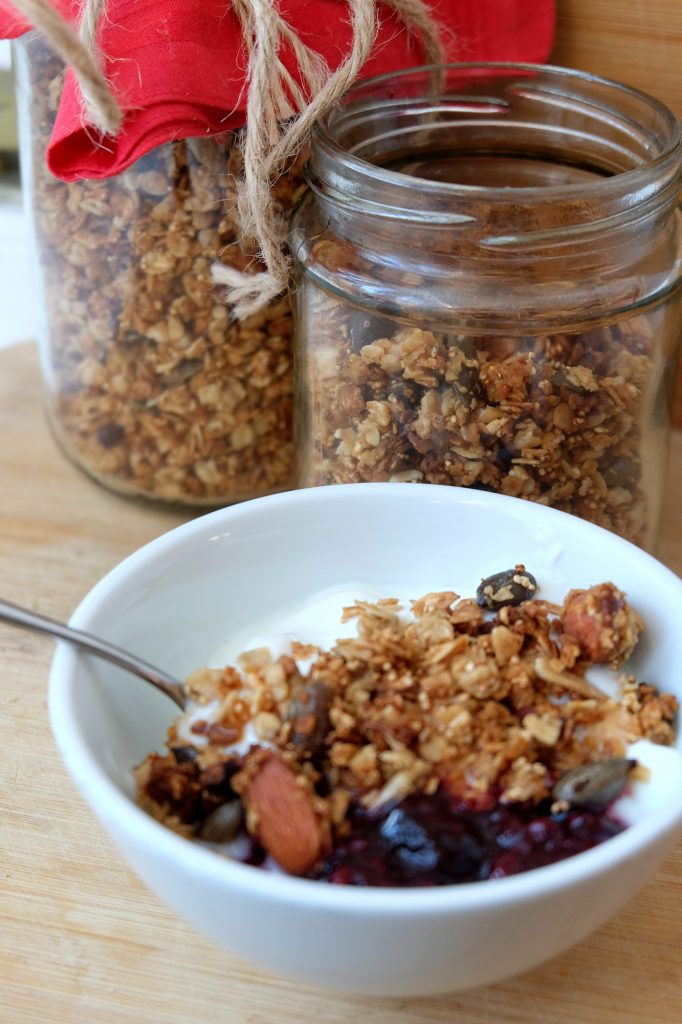 Granola in a bowl with jars full behind