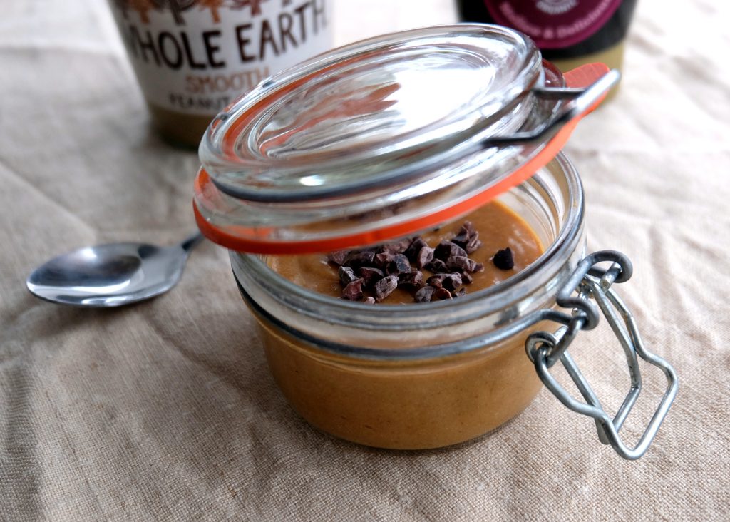 A jar with peanut butter pudding mousse and behind a jar of peanut butter