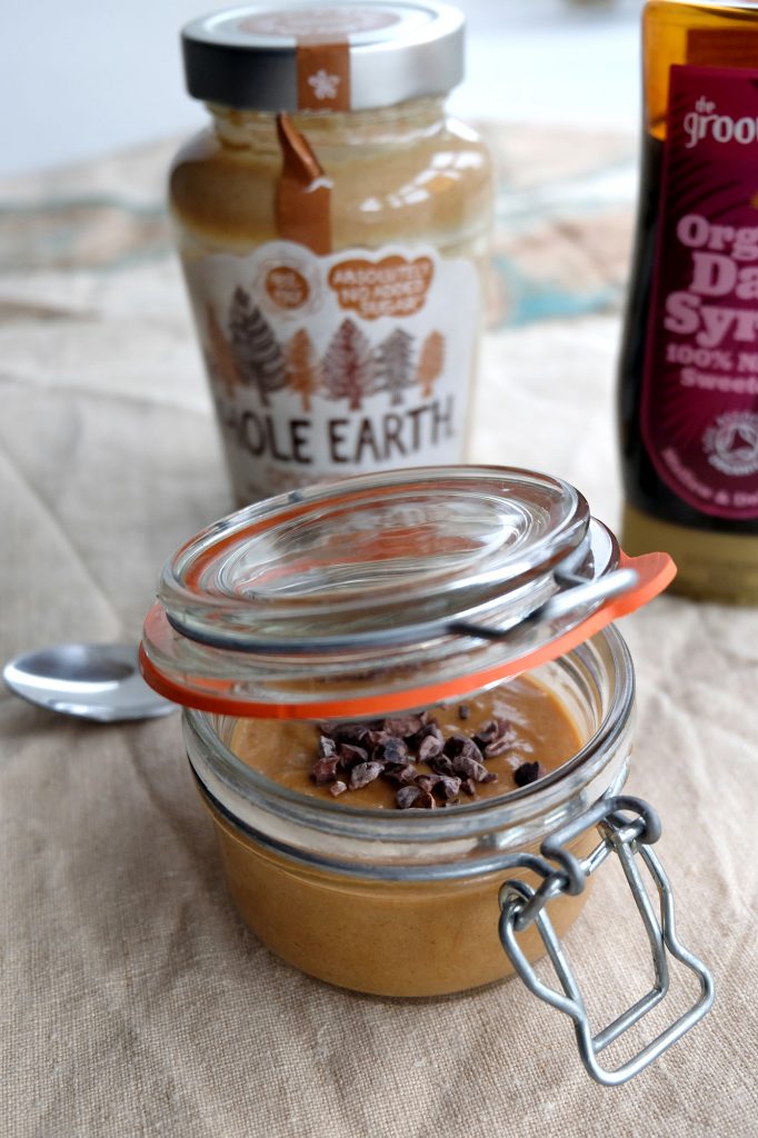 A jar with peanut butter pudding mousse and behind a jar of peanut butter