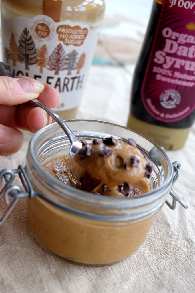 a spoon lifting some peanut butter mousse pudding out of a small jar